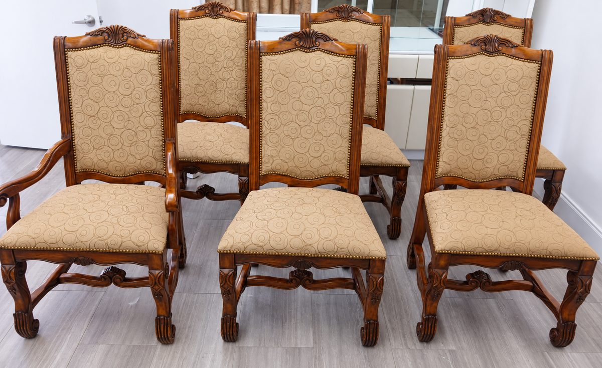Set of carved wood dining chairs with tan circle-pattern upholstered seats and backs.