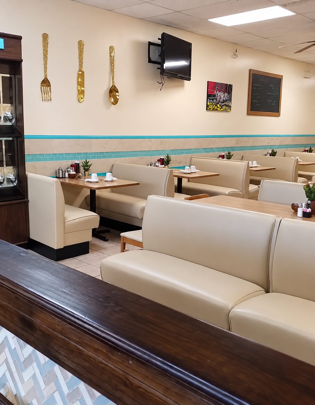 Cream upholstered booths and tables in a restaurant dining room.