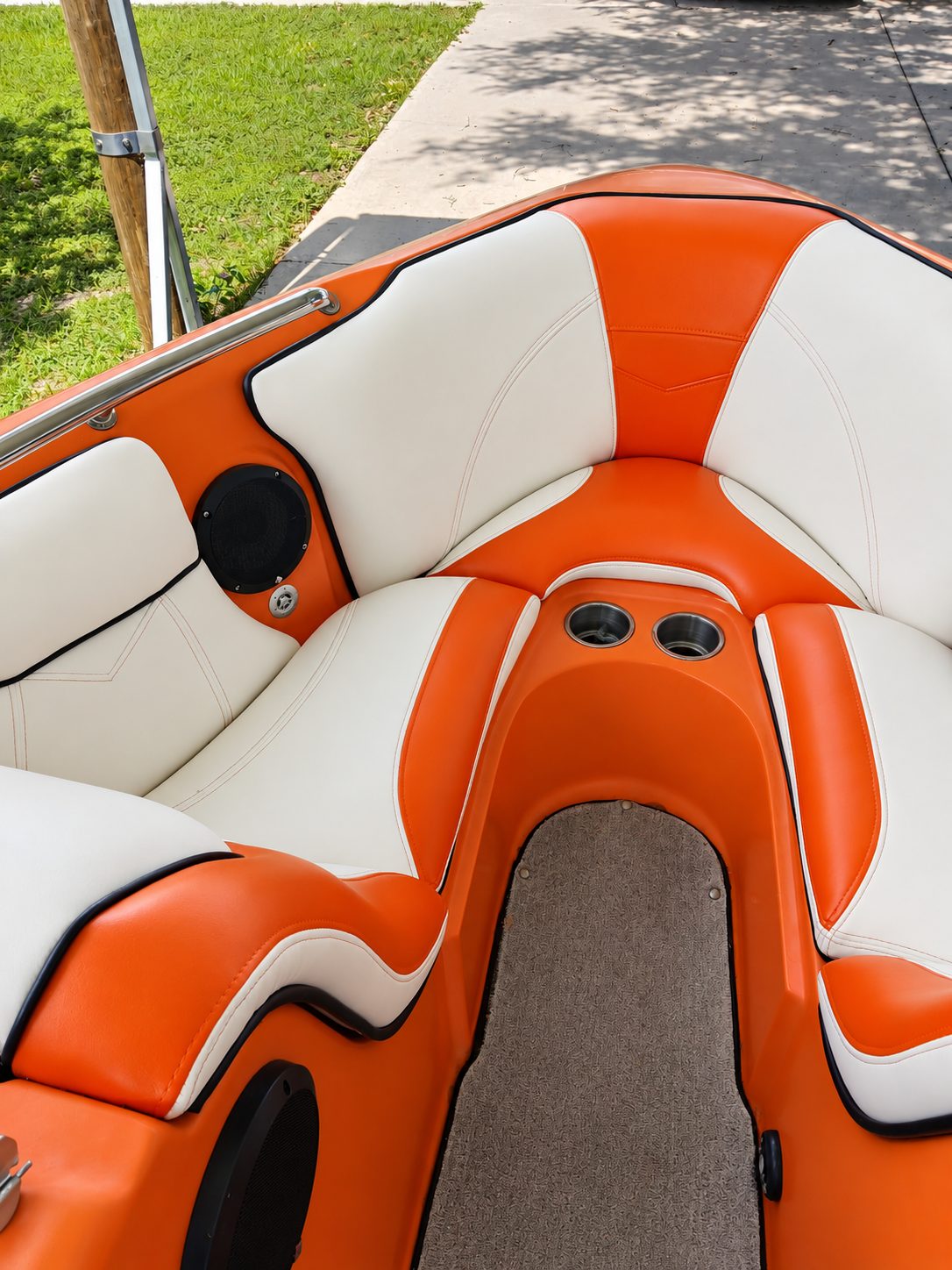Orange and white vinyl bow seating with built-in cup holders on a boat.