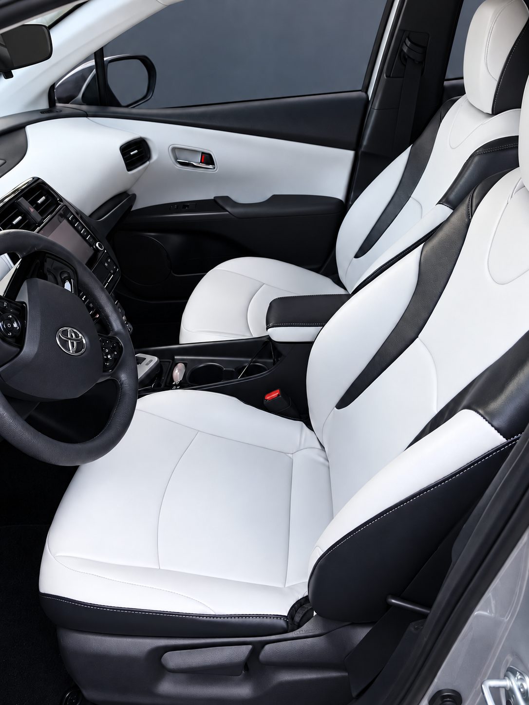White and black upholstered front seats inside a Toyota vehicle.