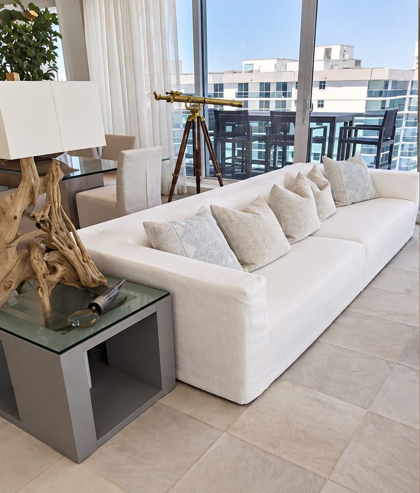 White sofa with textured pillows in a bright high-rise living room.
